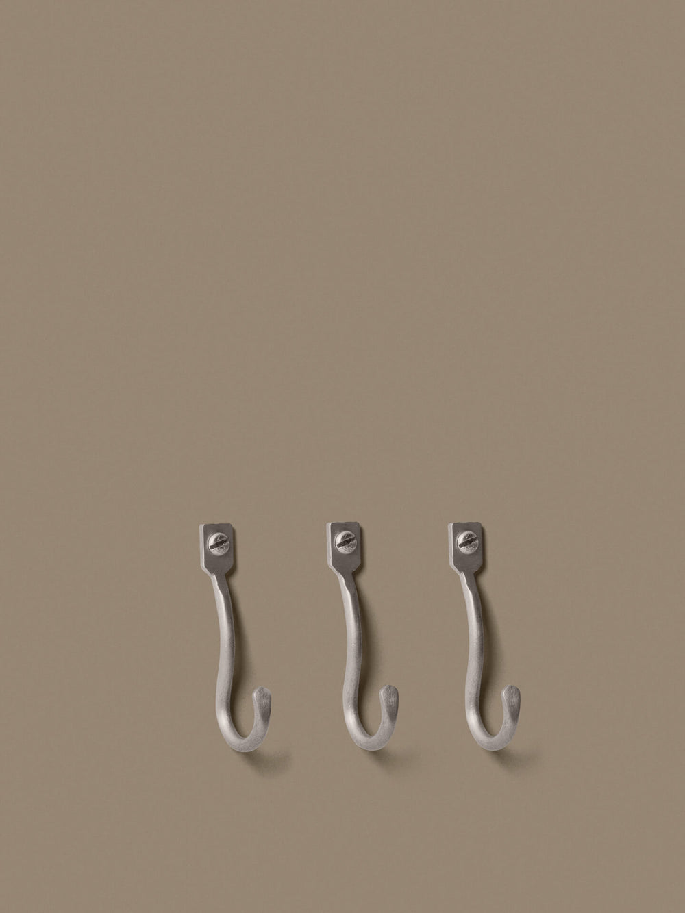 Three curved wall hooks mounted in a row, each with a single screw plate