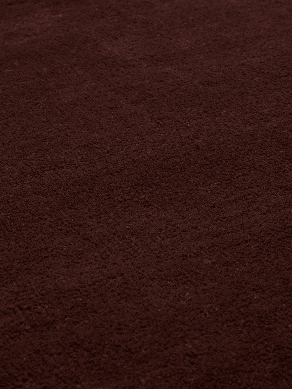 Close-up of the dense tufted pile in dark pecan