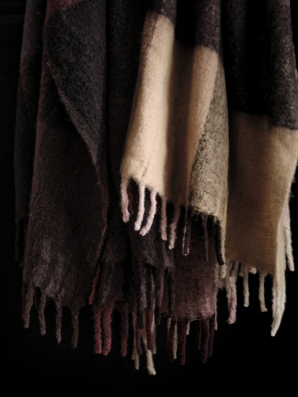 Close-up of the blanket's brushed checked surface and long fringed edge