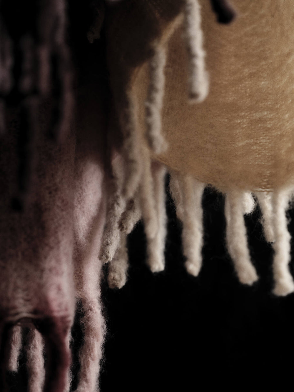 Close-up of the brushed surface and long fringes where butter and pale rose blur together