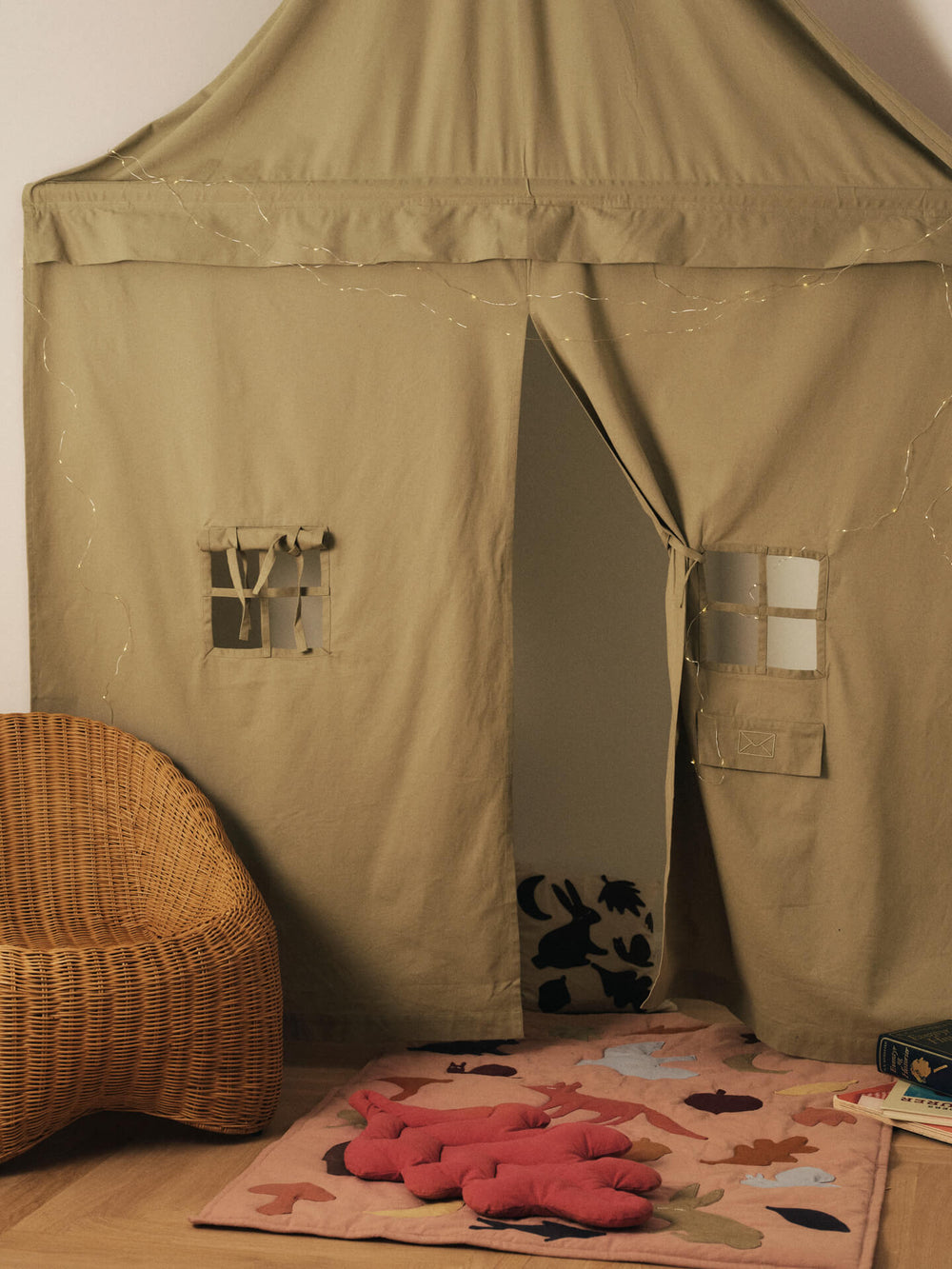 Children's corner with leaf-shaped cushions in baked clay on a patterned play mat by a tent