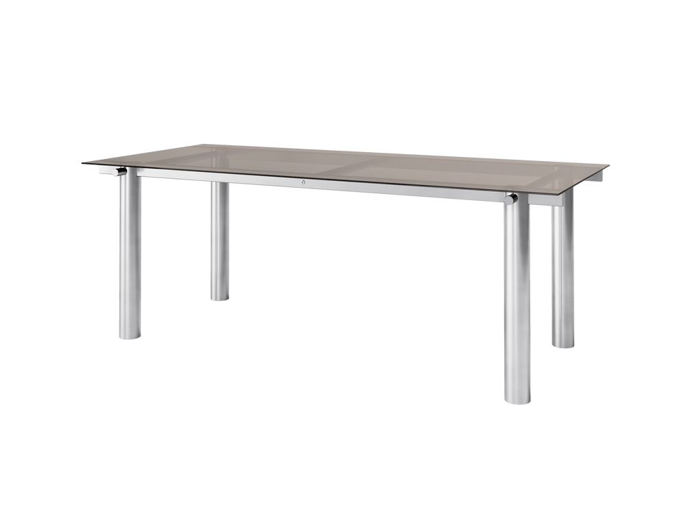 Dining table with tinted glass top and cylindrical brushed stainless steel legs, angled view