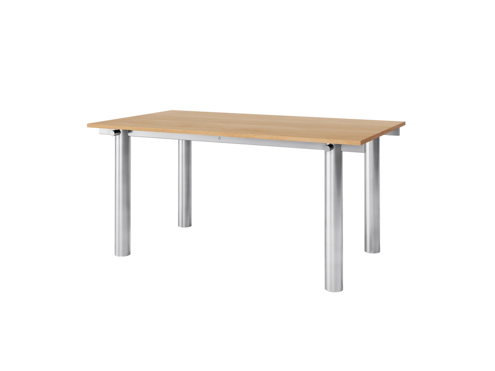 Dining table seen at an angle, brushed stainless steel frame with cylindrical legs and oak top